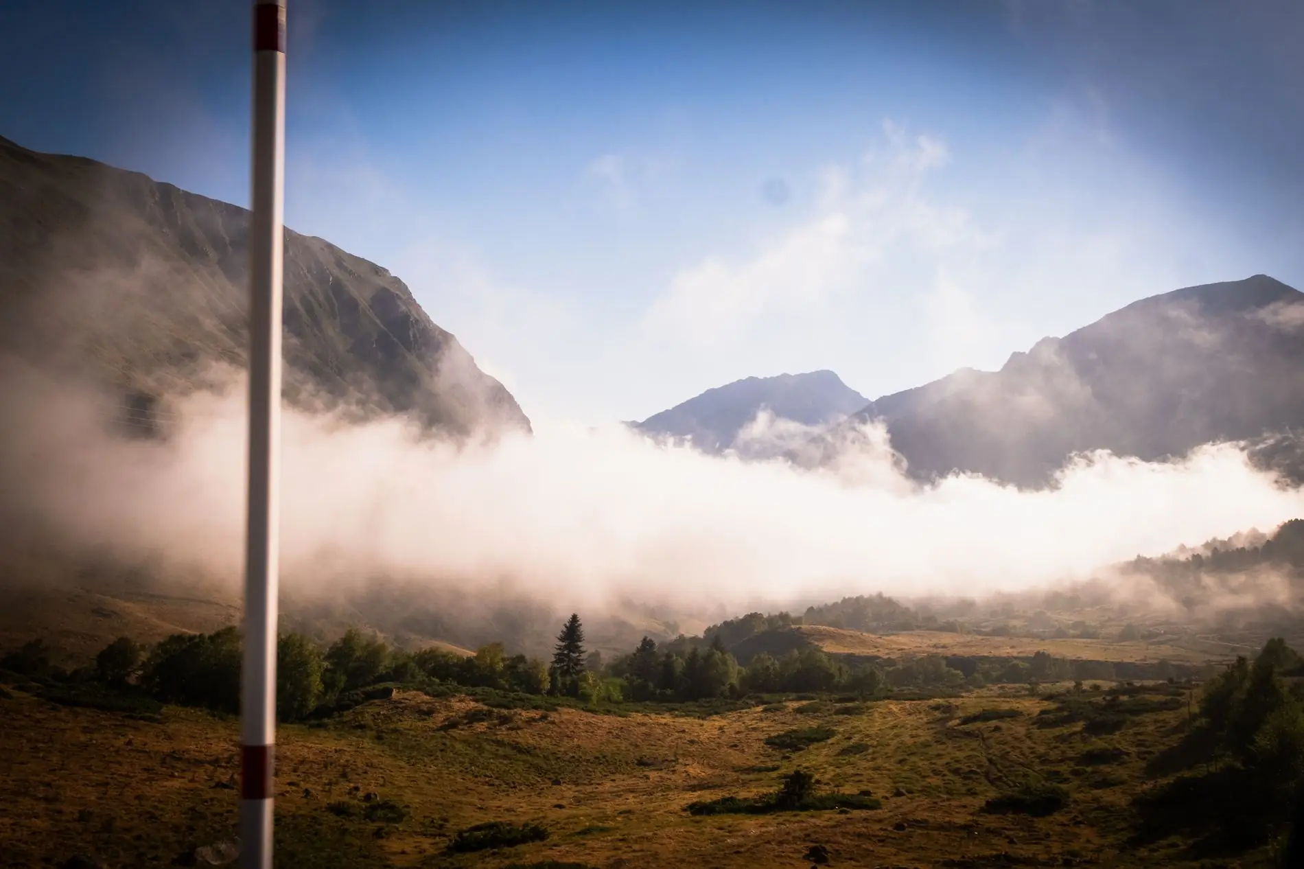 Niebla matinal cruzando un valle verde en los Pirineos de Andorra