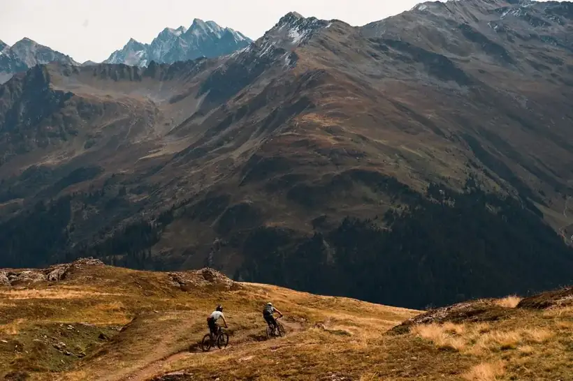 Ciclista de montaña con picos glaciares espectaculares de fondo